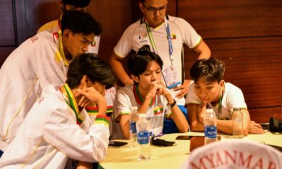 Myanmar eSport members watch a game on a phone at the SEA Games