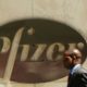 A man walks past the Pfizer logo on the drug maker's headquarters in New York