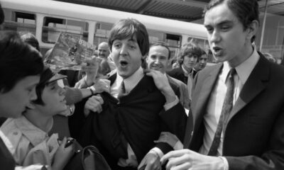 Fans surround the Beatles' members Paul McCartney (C) and George Harrison (2nd R) at their arrival at Orly airport on June 20, 1965, before their concert at the Palais des Sports the same evening