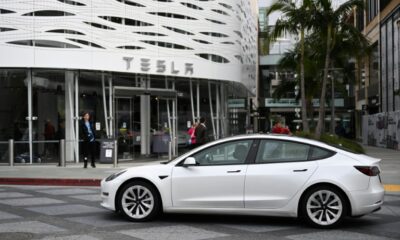 A Tesla electric vehicle drives past the Tesla Inc Santa Monica Place store, in Santa Monica, California