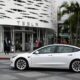 A Tesla electric vehicle drives past the Tesla Inc Santa Monica Place store, in Santa Monica, California