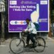 A man rides past an election awareness poster displayed on a street ahead of India’s upcoming general elections, in Hyderabad